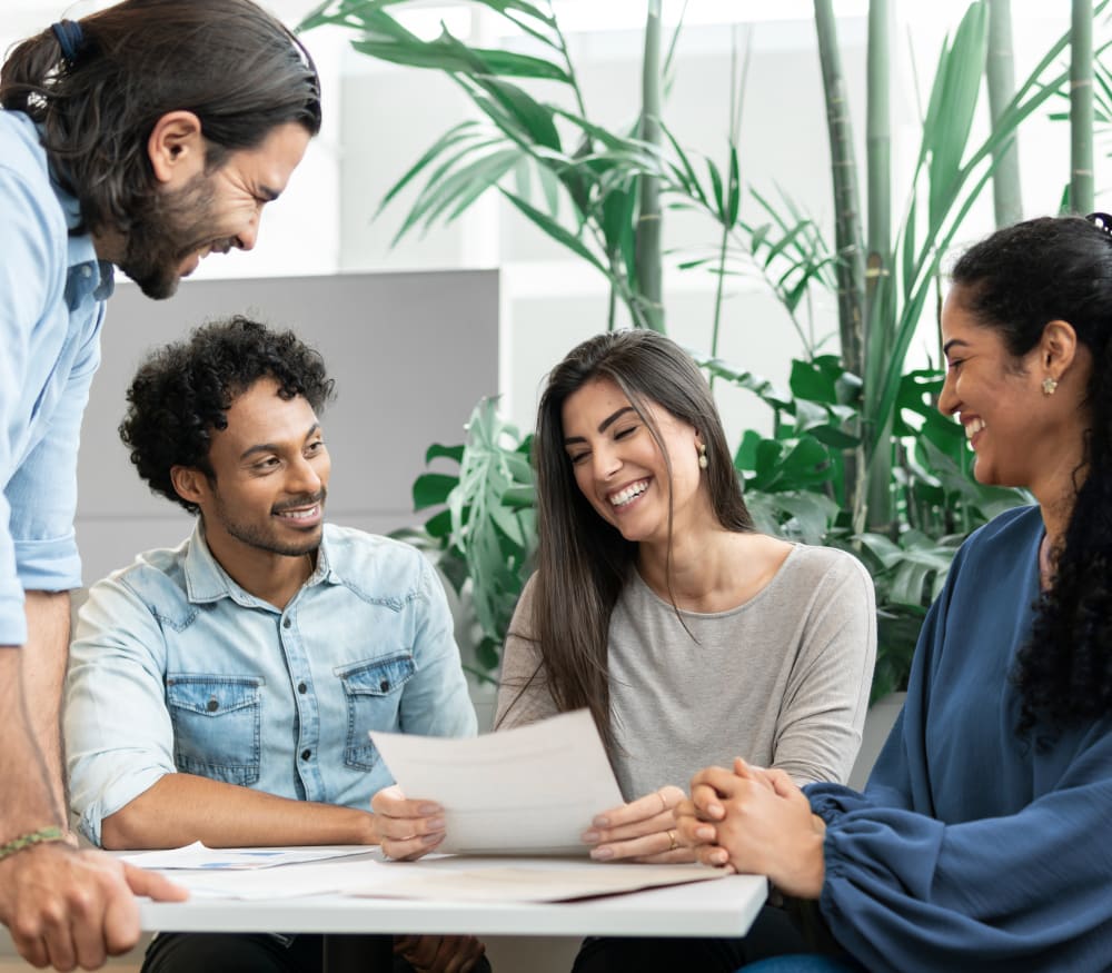A group of four are around a table working on some documents.