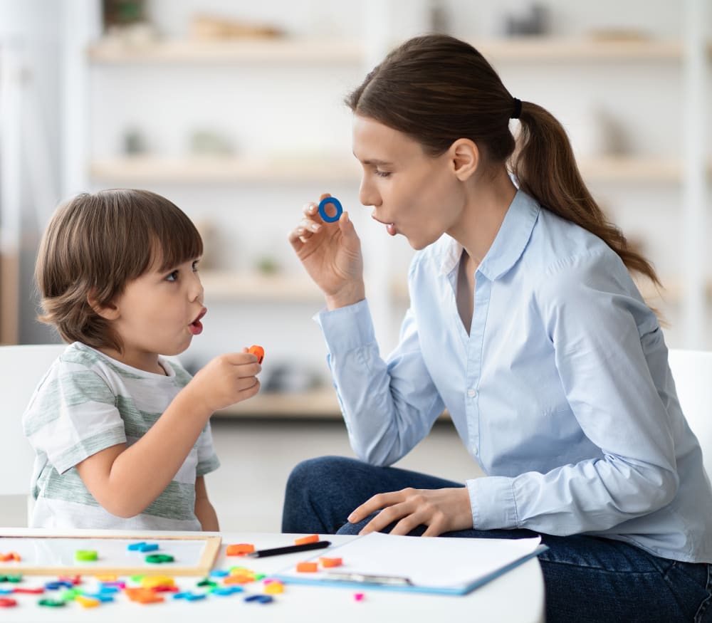 A speech-language pathologist works with a young boy.